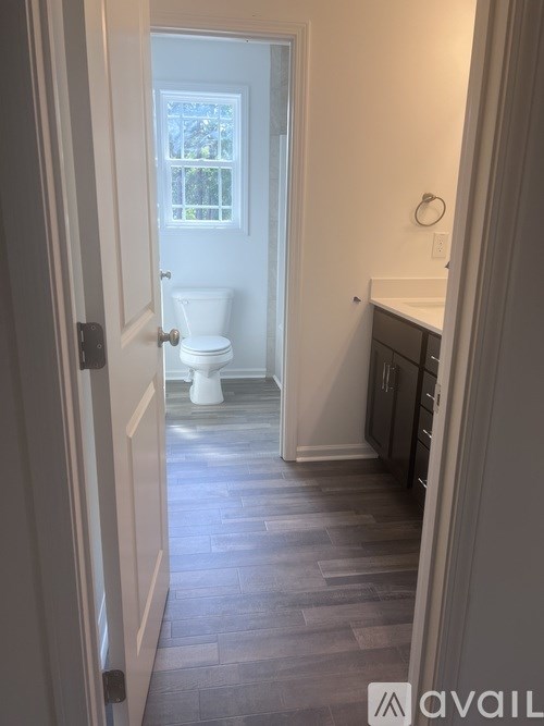 A bathroom with a toilet and a window.