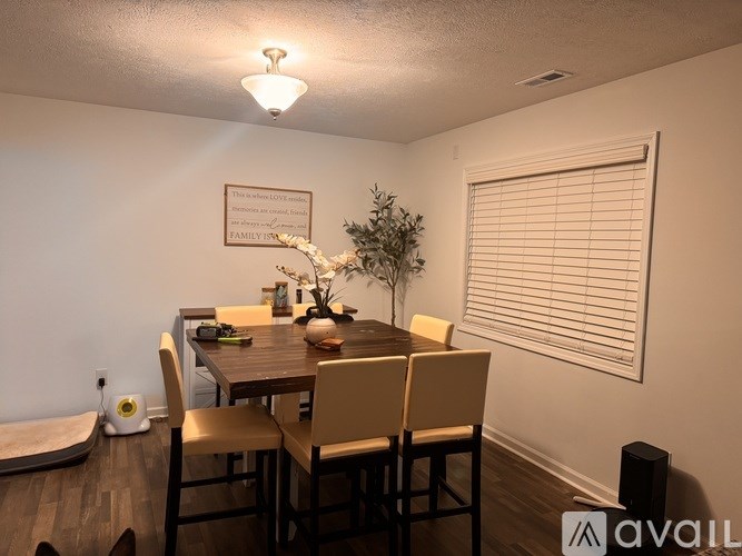A dining room with a wooden table and chairs.