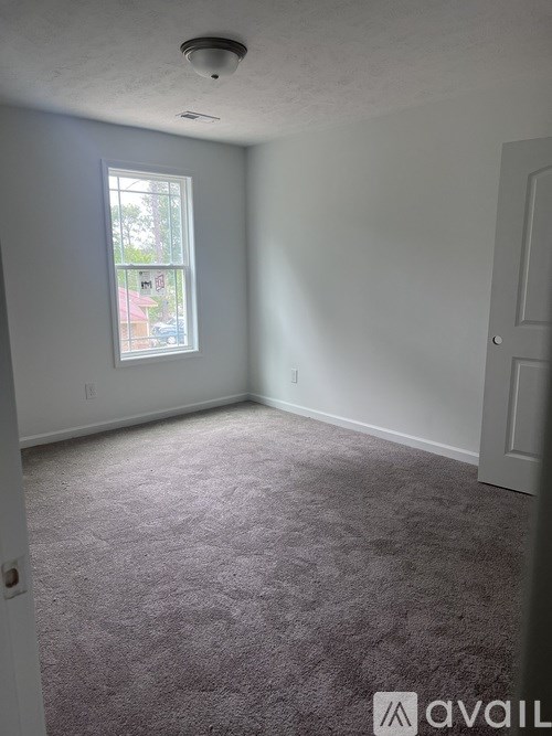 A room with a window and carpeted floor.