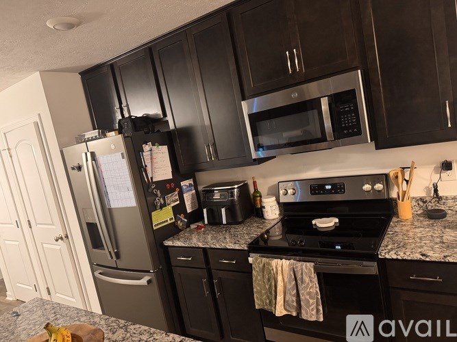 A kitchen with black cabinets and a black stove top oven.
