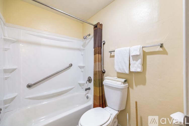 A white toilet sits next to a bathtub in a bathroom.