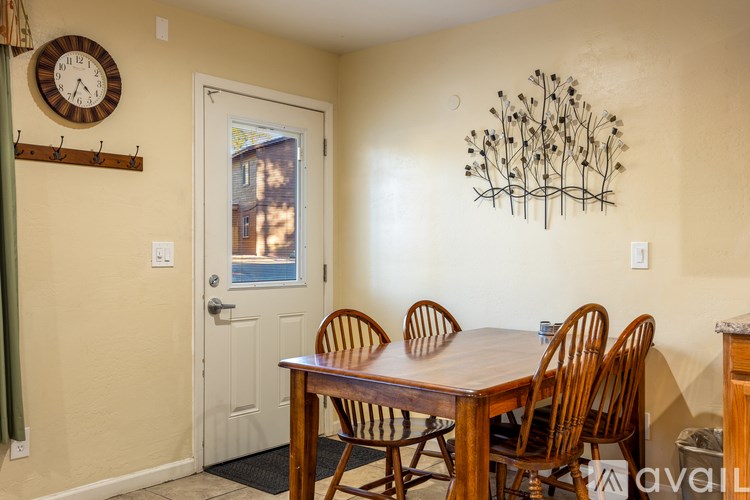 A dining room with a wooden table and chairs.