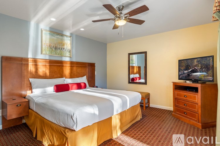 A bedroom with a large bed and a ceiling fan.