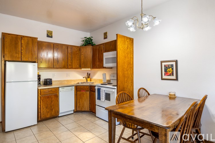 A kitchen with wooden cabinets and a white refrigerator.