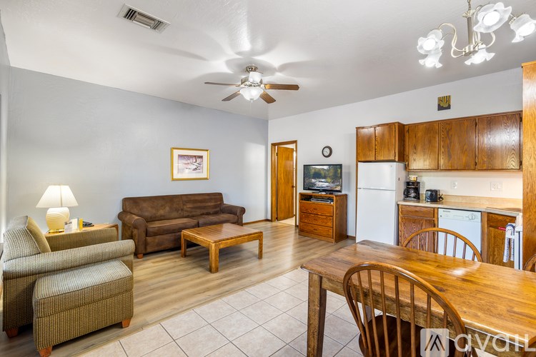 A living room with a couch, chair, and a television.