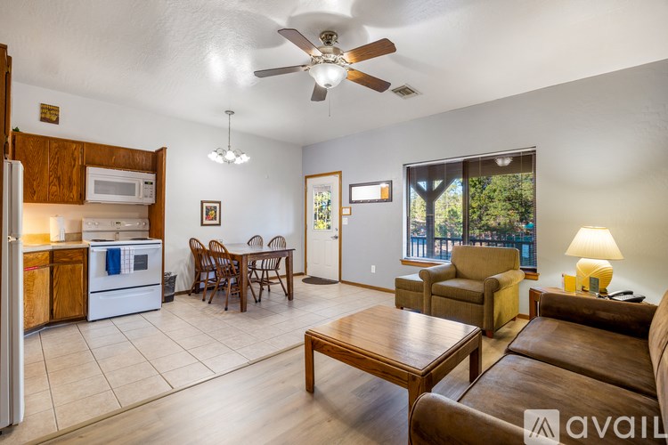 A living room with a brown couch and a dining table.