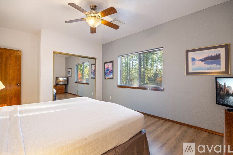 A bedroom with a large bed and a ceiling fan.