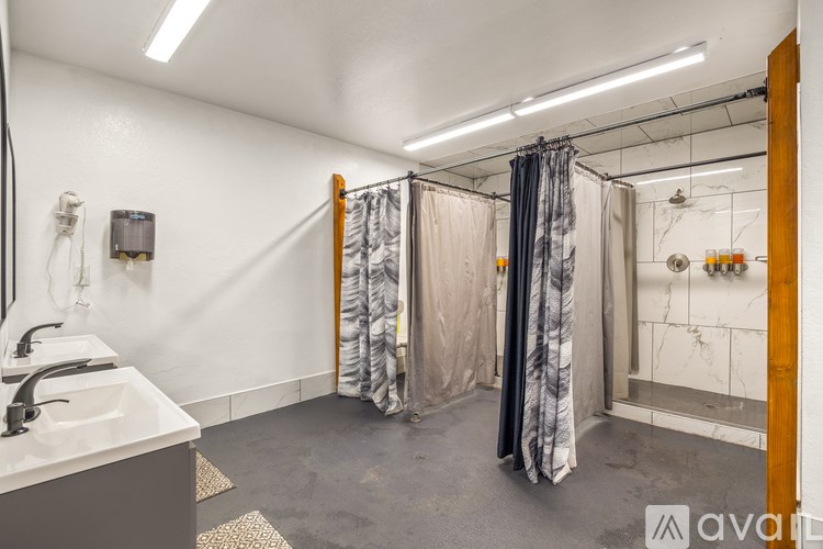 A bathroom with a sink, mirror, and shower area.