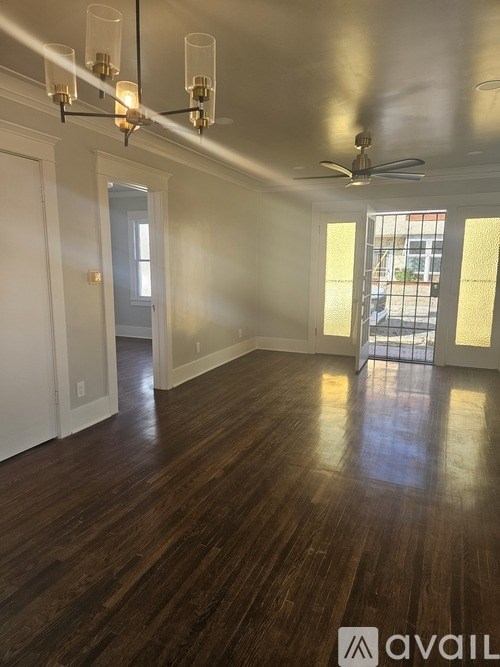 A room with wooden floors and a ceiling fan.