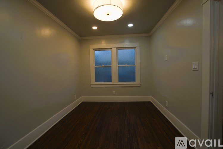 A room with a window and wooden floors.