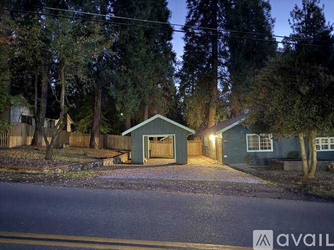 A house with a garage is lit up at night.
