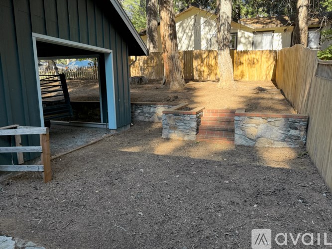 A backyard with a green shed and a wooden bench.