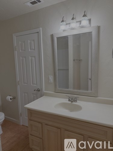 A bathroom with a sink, mirror, and toilet.