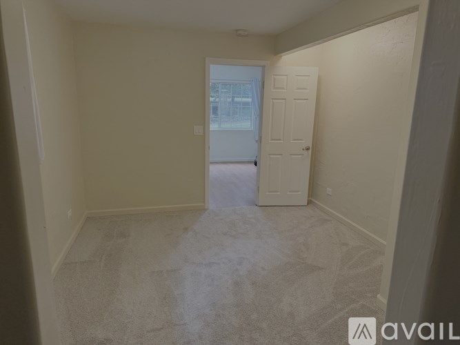 A room with a carpeted floor and a door leading to a balcony.