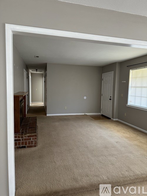 A room with beige carpet and white walls is available for rent.
