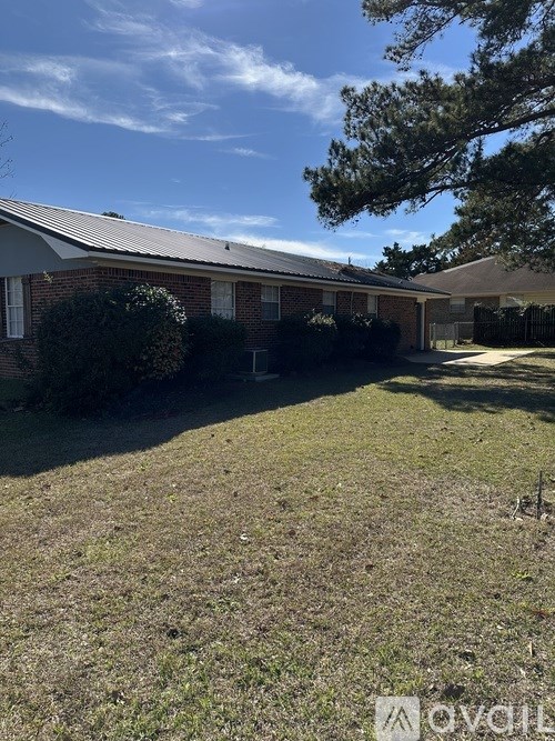 A house with a grey roof and a green lawn in front.
