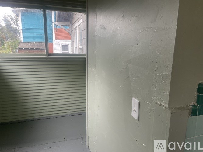 A room with a window covered by a grey roller blind.