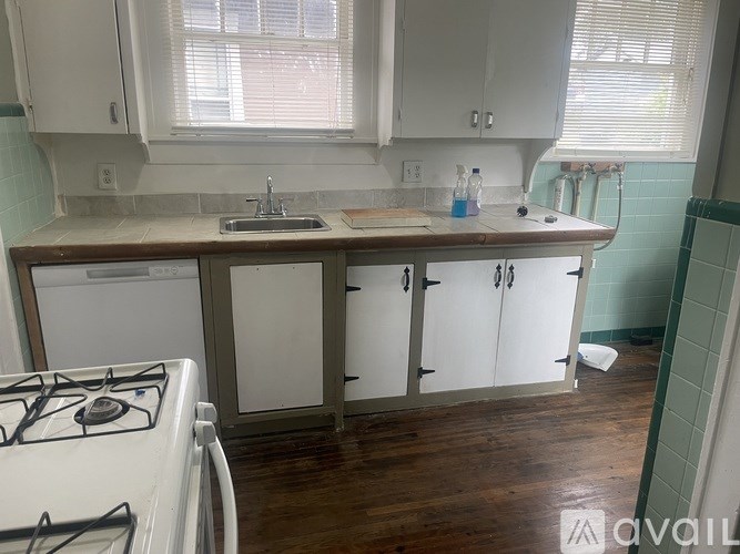 A kitchen with a white stove and cabinets.