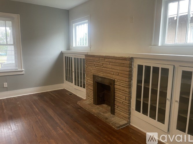 A room with a fireplace and wood flooring.