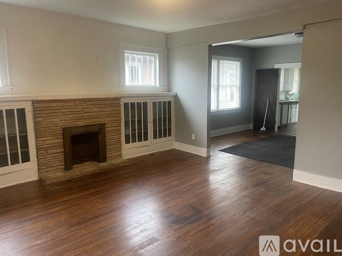 A room with a fireplace and wood flooring.