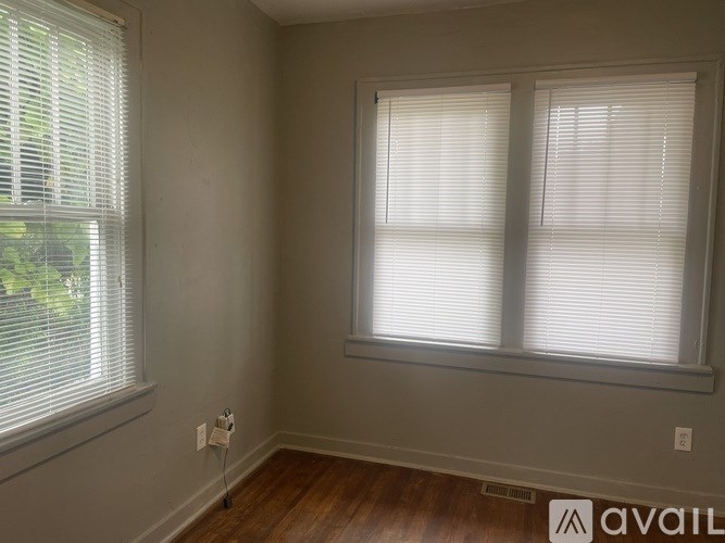 A room with a window and a wooden floor.