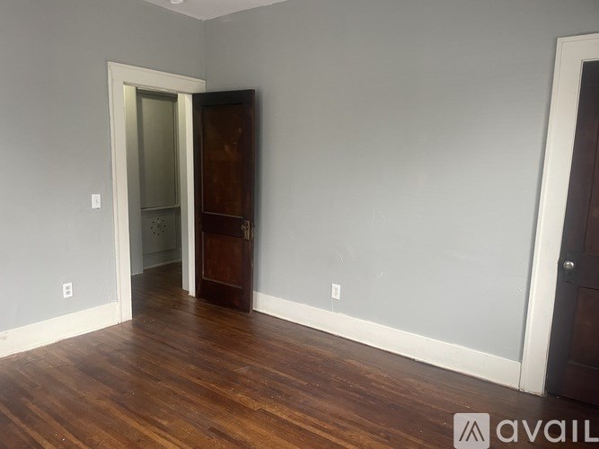 A room with a wooden floor and a white door.