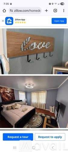 A bedroom with a bed, a mirror, and a wooden sign that says "Welcome".