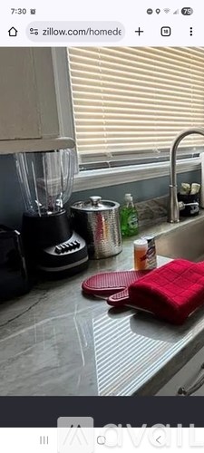 A kitchen counter with a blender, a can, and a red container.