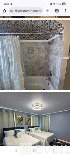 A bedroom with two beds and a shower curtain.