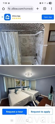 A bedroom with two beds and a shower with a zillow.com link.