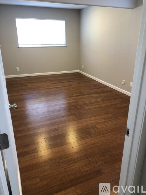 A room with wooden flooring and a window.