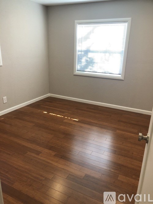 A room with wooden flooring and a window.