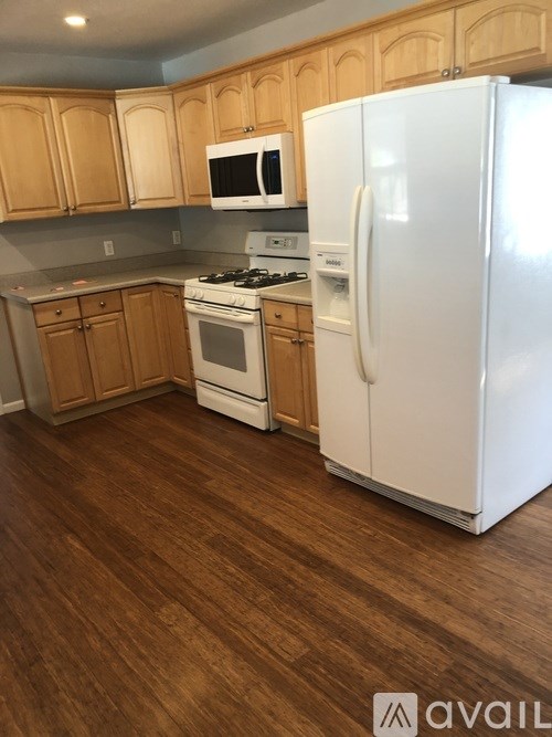 A kitchen with wooden cabinets and a white refrigerator.