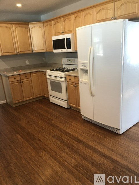 A kitchen with wooden cabinets and a white refrigerator.