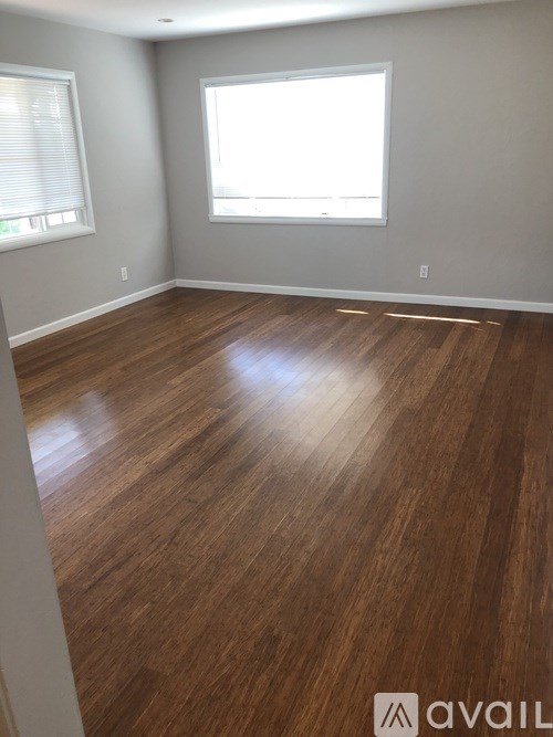 A room with wooden flooring and a window.