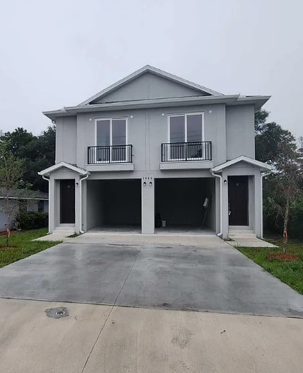 A grey two-story house with a balcony and a garage.
