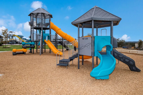 A playground with a blue slide and a yellow slide.