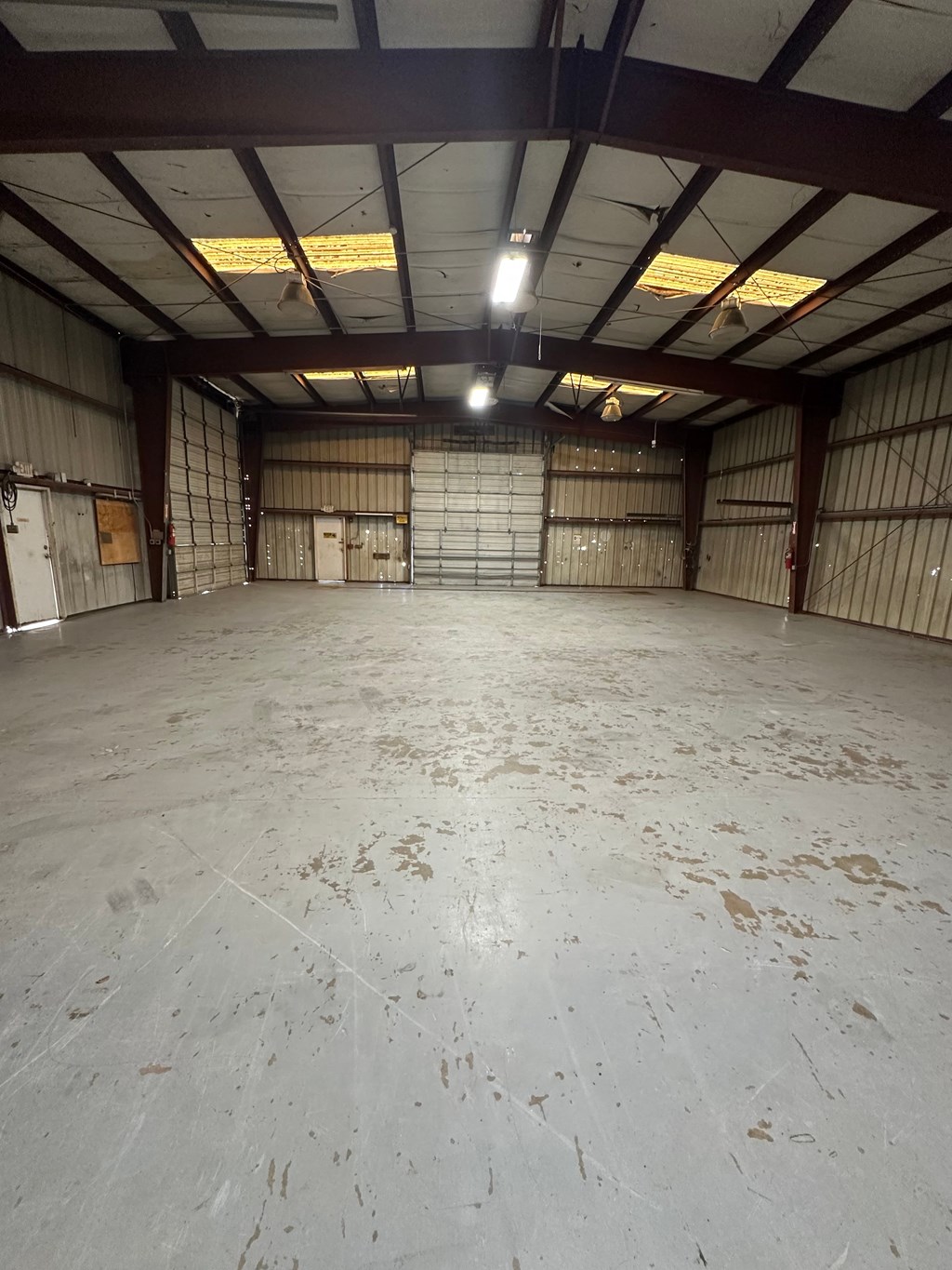 A large, empty warehouse with a concrete floor and metal walls.