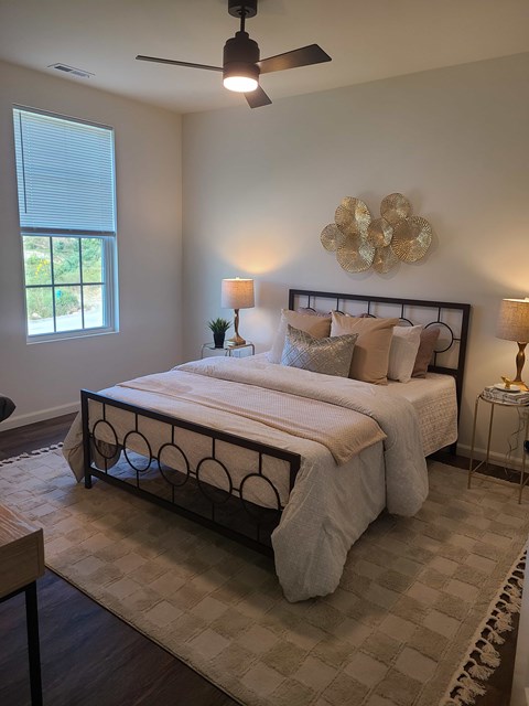 A bedroom with a large bed and a ceiling fan.