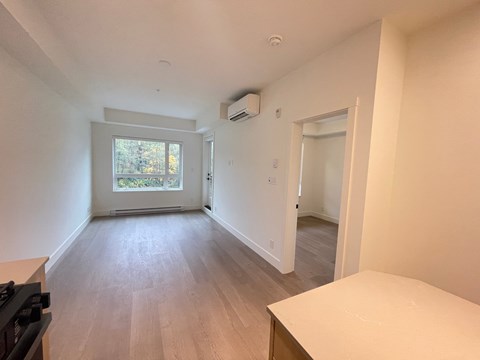 A room with a window, a stove, and a table.