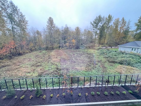 A backyard with a fence and a house in the background.