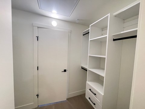 A white closet with shelves and drawers.