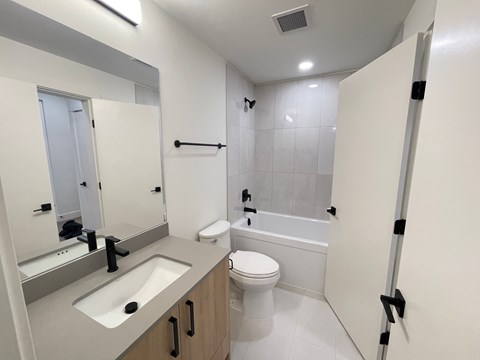 A bathroom with a toilet, sink, and bathtub.