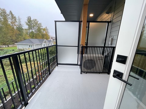 A balcony with a black railing and a white door.