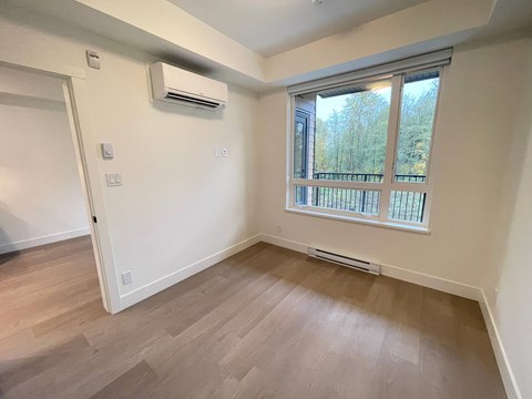 A room with a window and a balcony railing.