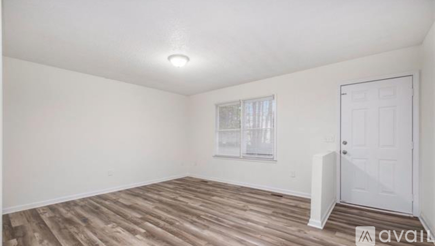 A room with wooden flooring and a white door.