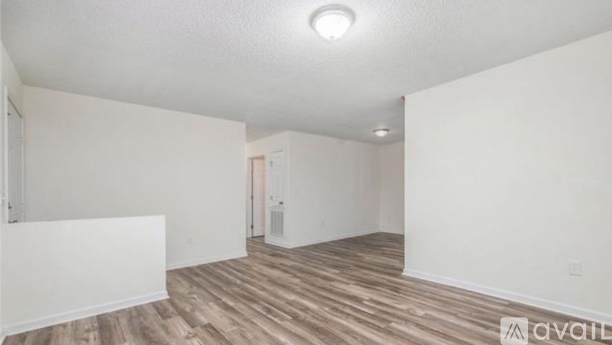 A room with wooden flooring and white walls is available for rent.