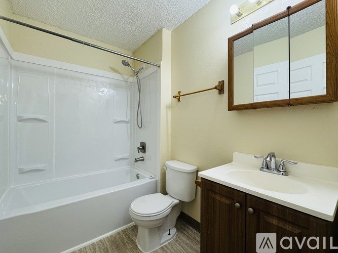 A bathroom with a white toilet, a white sink, and a white bathtub.