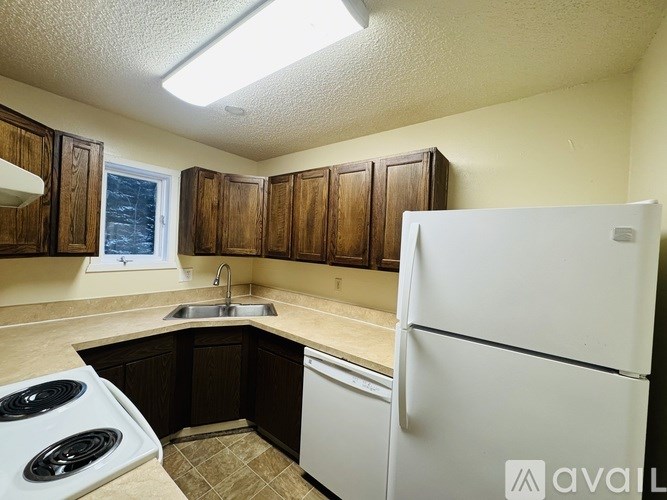 A kitchen with a white fridge and a white stove.
