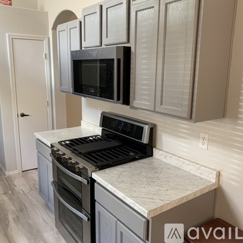 A kitchen with a black microwave above a stove top oven.